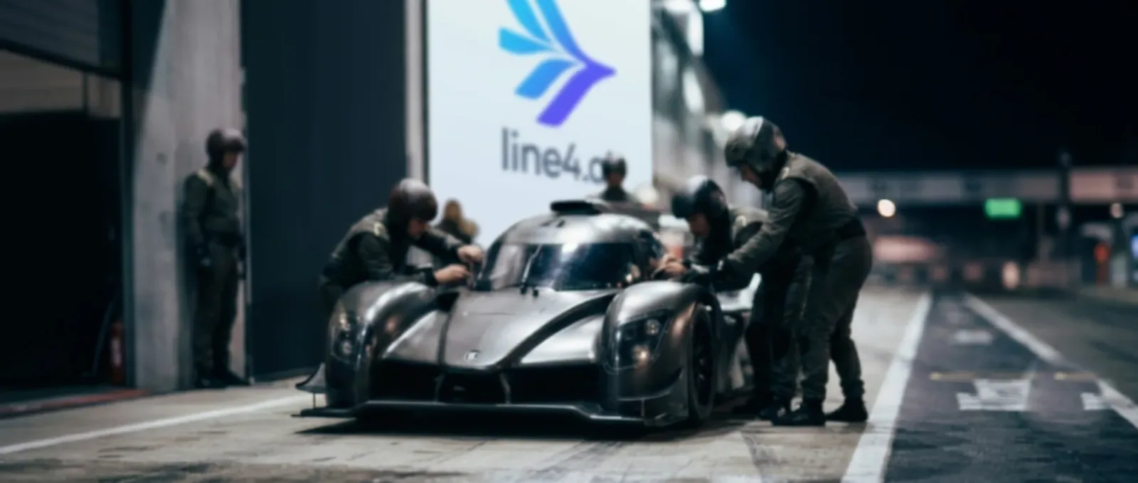 Line4 pit crew working on a race car under floodlights at night